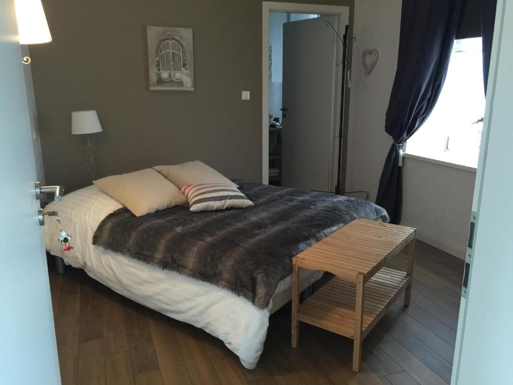 a bedroom with a bed and a table and a window at Chambres d&#39;hôtes - L&#39;Ecurie Obernai in Obernai