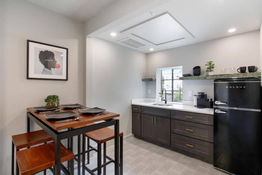 a kitchen with a table and a black refrigerator at Double Queen Suite 2nd Floor Downtown Savannah in Savannah