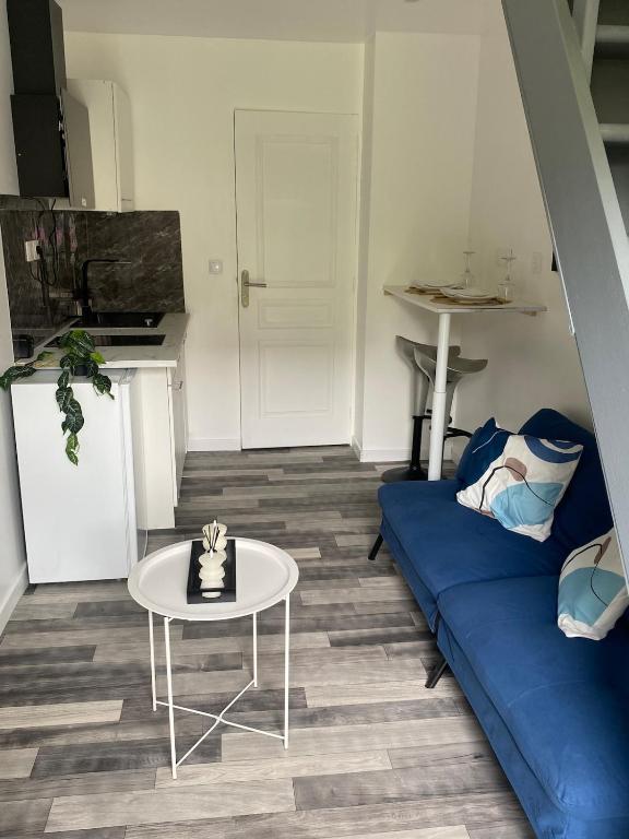 un salon avec un canapé bleu et une table dans l'établissement Chez Nenette & Didi Cozy Independent Duplex, à La Celle-sous-Gouzon