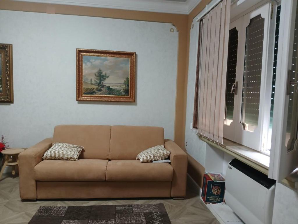 ein Wohnzimmer mit braunem Sofa und einem Fenster in der Unterkunft B&B Federico in San Demetrio Corone