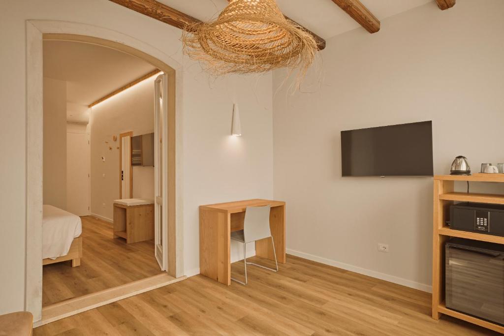 een kamer met een bed, een tafel en een televisie bij Hotel Le Mura in Lazise