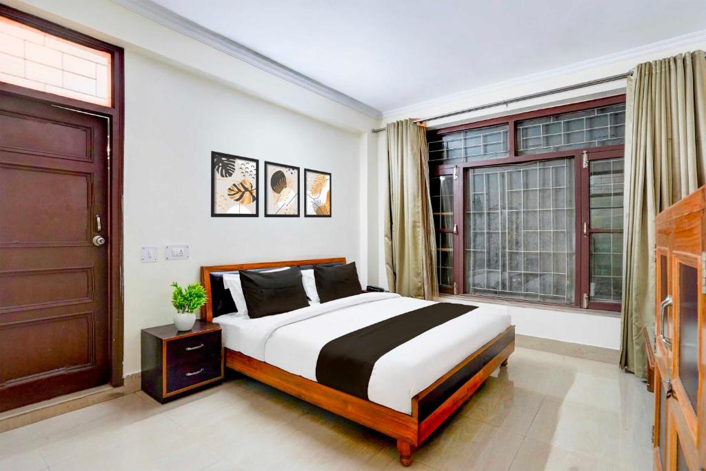a bedroom with a bed and a large window at Collection O Mall Road Library Chowk in Mussoorie