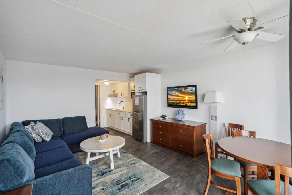 Una sala de estar con un sofá azul y una mesa. en 6201 Ocean Ave, Unit 409 - The Nassau Inn, en Wildwood