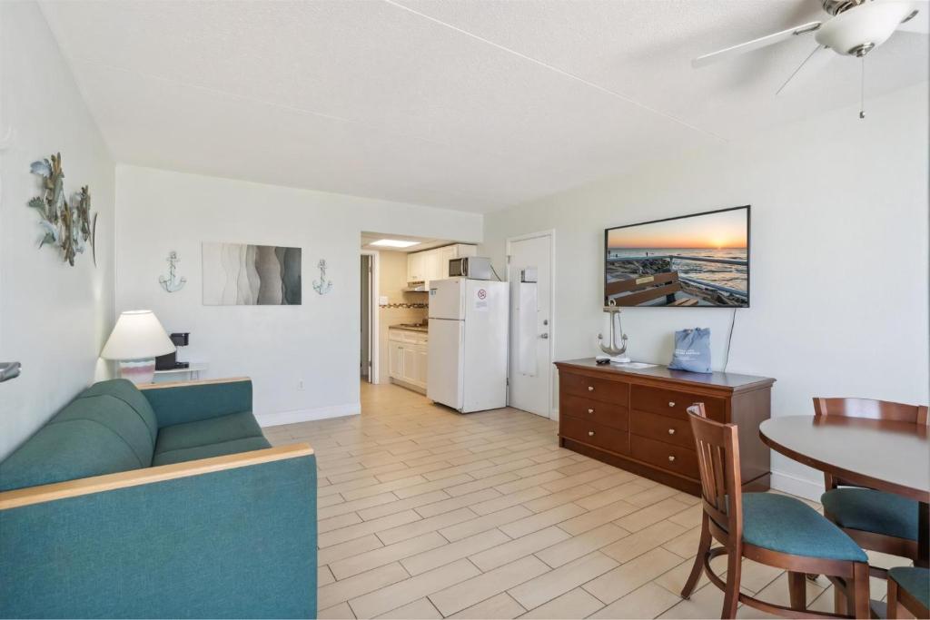 Una sala de estar con un sofá azul y una mesa. en 6201 Ocean Ave, Unit 304 - The Nassau Inn, en Wildwood