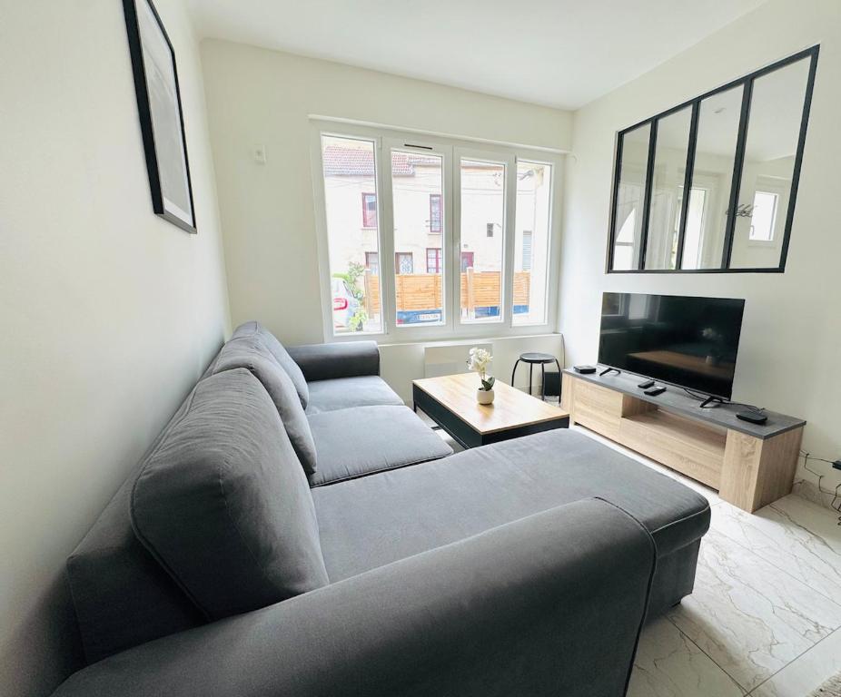 a living room with a couch and a tv at Maison design pour 8 pers proche Paris et Disney in Villiers-sur-Marne