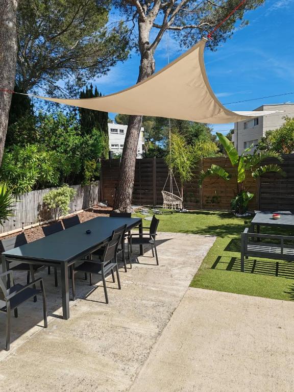 - une table de pique-nique avec un auvent dans le jardin dans l'établissement Villa pour 6 voyageurs, piscine, jardin, terrain de boule et parking privé, à Saint-Raphaël