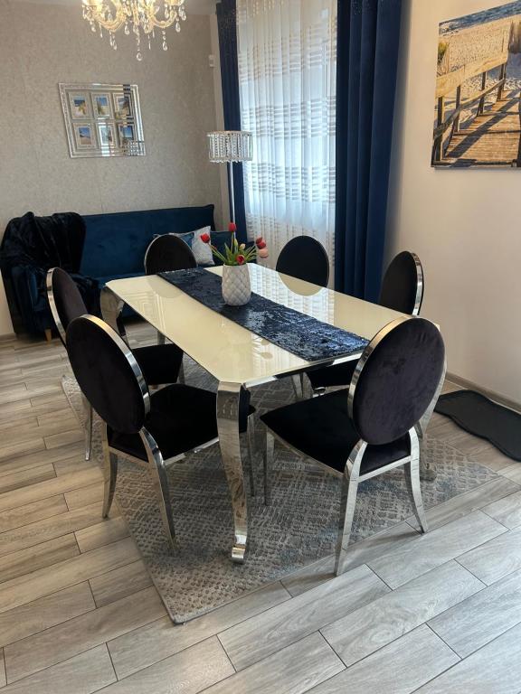 a dining room table with chairs and a blue couch at Emilia domki U Przyjaciół in Żarnowska