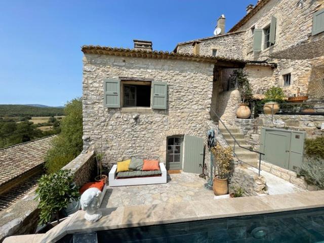 une maison avec une piscine à côté d'un bâtiment dans l'établissement Oppida Lussan, à Lussan