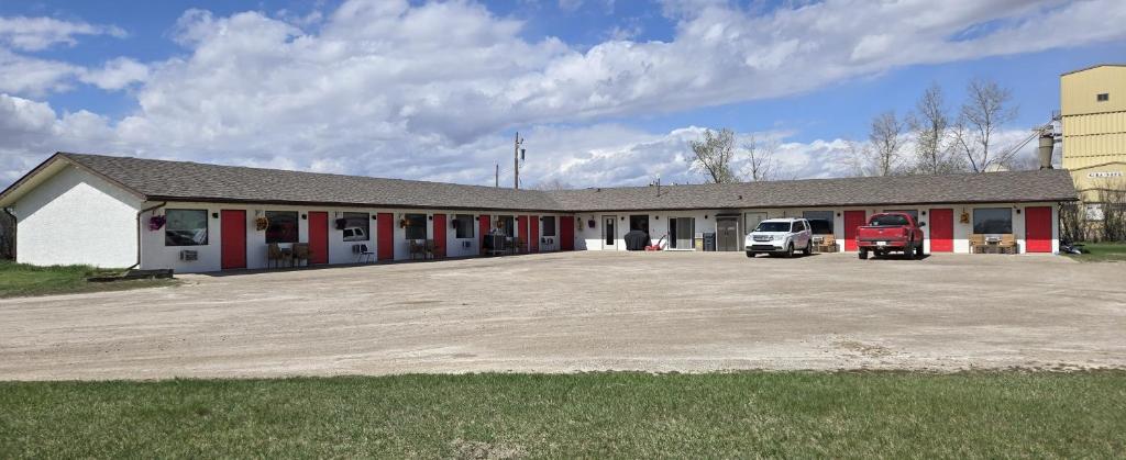a large building with a truck parked in a parking lot at Blue Horse Motel in Beiseker