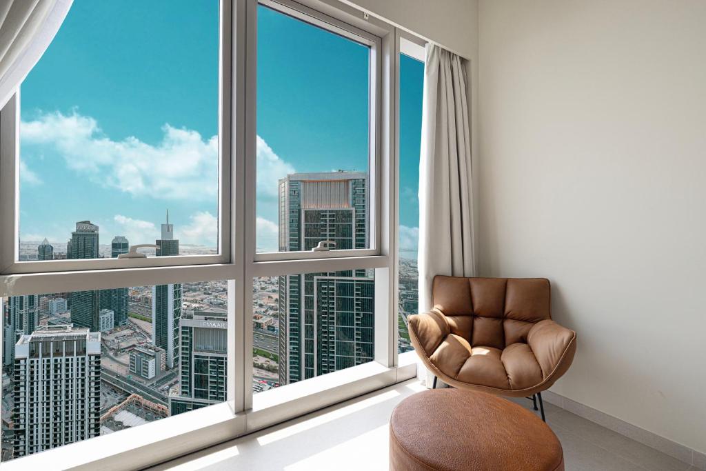 a room with a chair and a large window at Luxury 2BR Sea View Walk to Burj & Dubai Mall in Dubai