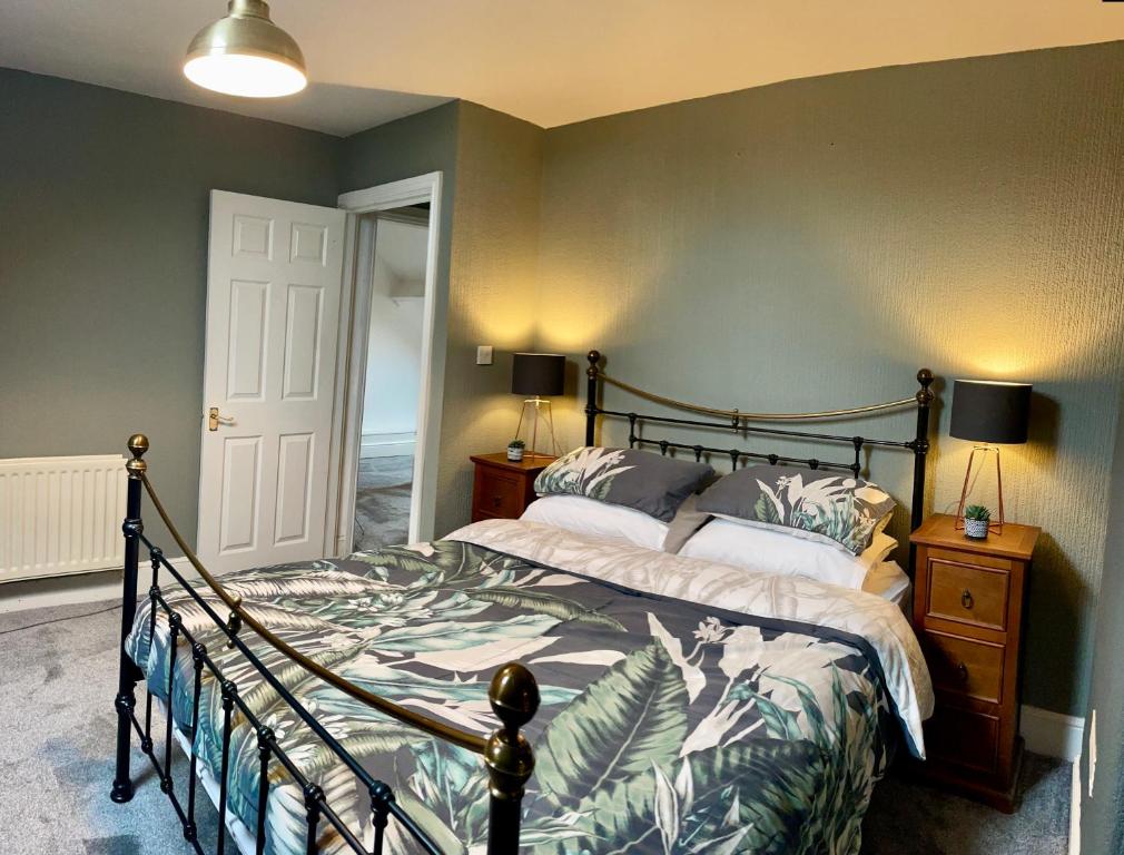 ein Schlafzimmer mit einem großen Bett mit Holzrahmen in der Unterkunft Cosy Loft Apartment with Sea Views Above Village Pub The Stag Inn Crosby Maryport in Crosby