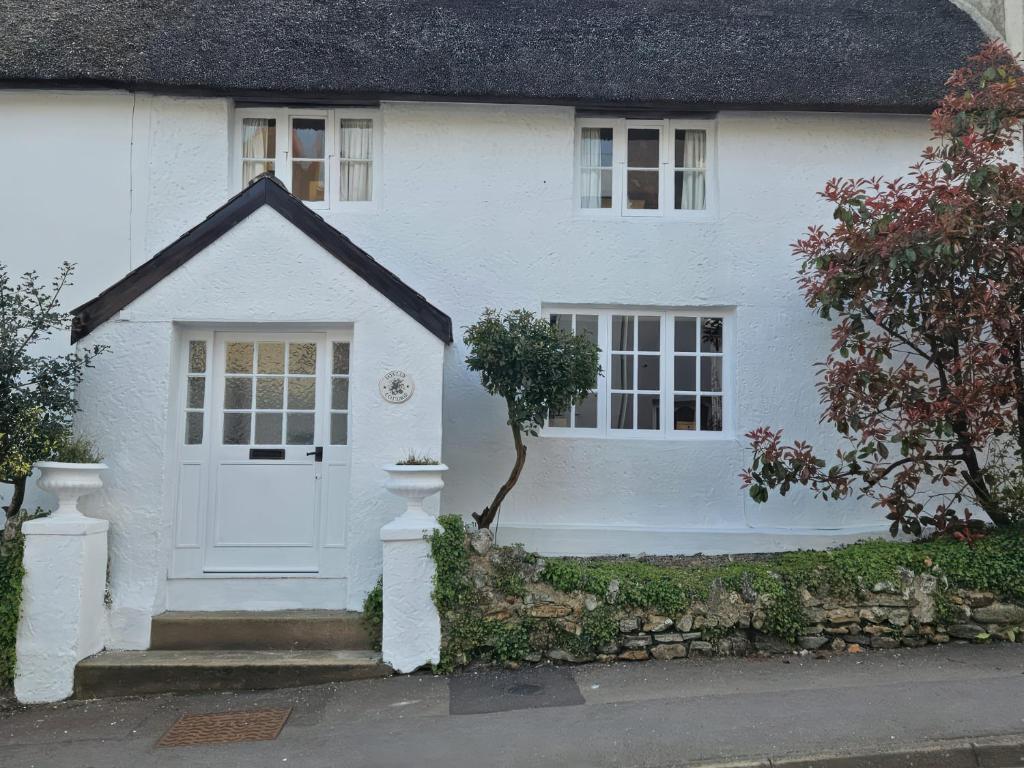 a white house with a white door at Foxley Cottage in Charmouth
