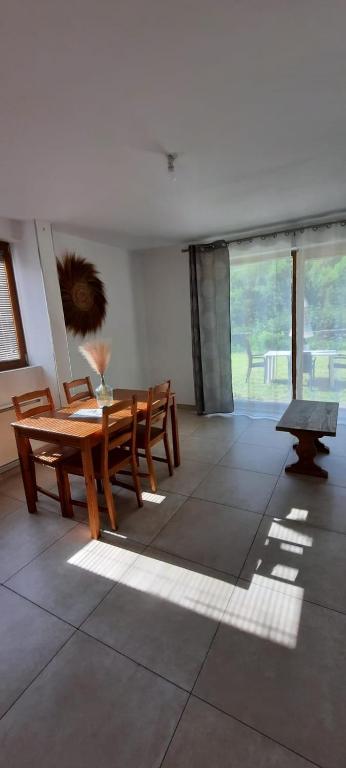 une salle à manger avec une table et un banc dans l'établissement Appartement avec jardin, au Bourg-dʼOisans