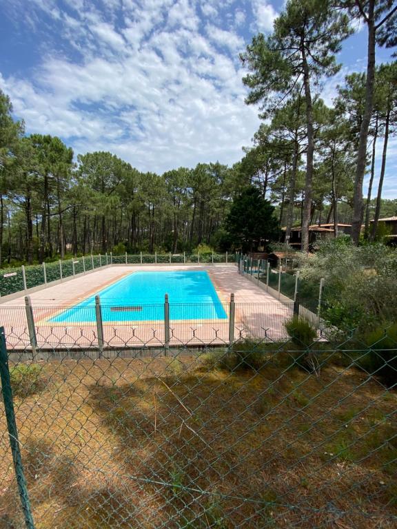 une piscine vide derrière une clôture dans l'établissement Maison dans la pinède, à Lacanau