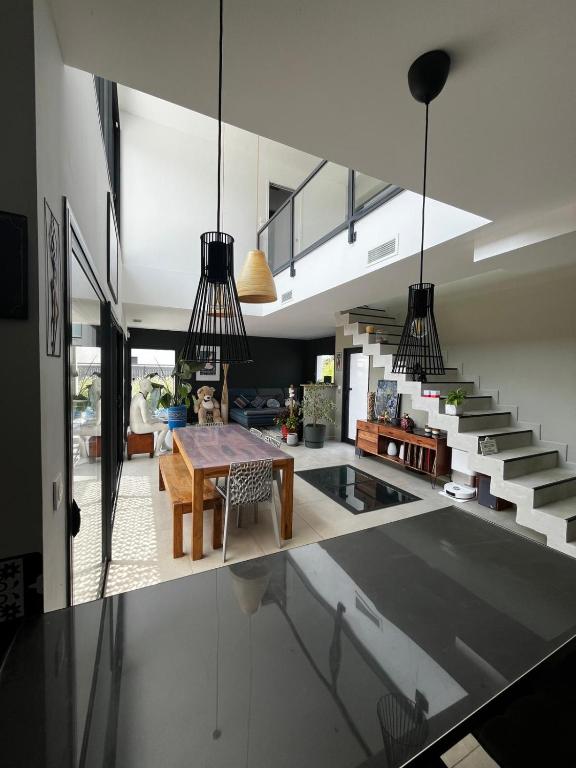 - une cuisine et une salle à manger avec une table et des escaliers dans l'établissement Villa des Bananiers, à Baillargues