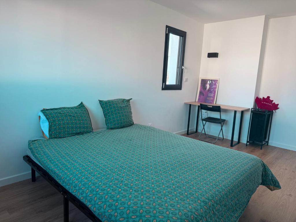 una camera da letto con un letto con un piumone verde di Villa des Bananiers a Baillargues