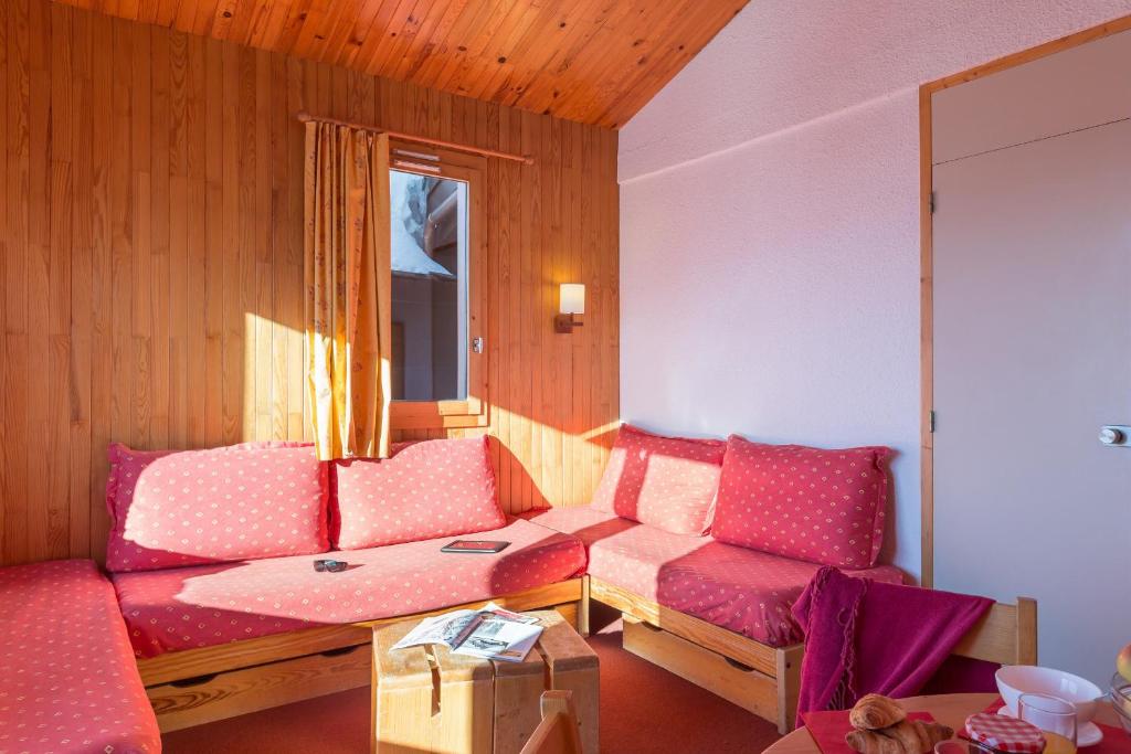 a living room with pink couches and a window at Résidence Pierre &amp; Vacances Emeraude in Belle Plagne