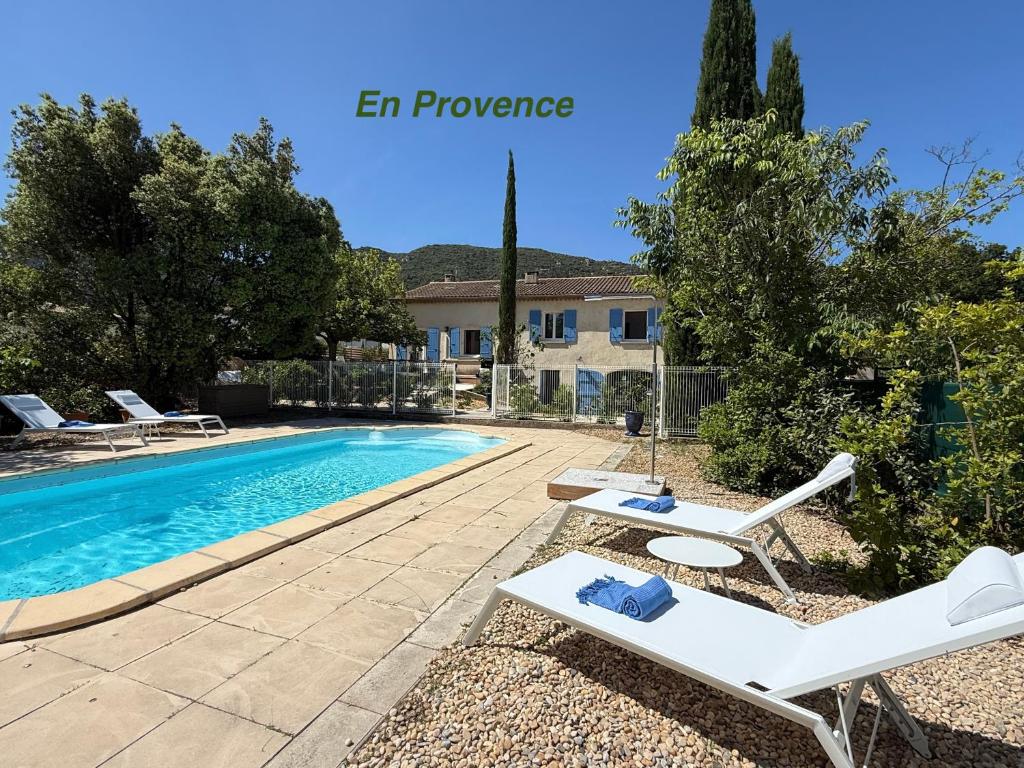 une villa avec une piscine et deux chaises longues dans l'établissement La Note Bleue Luberon, à Maubec
