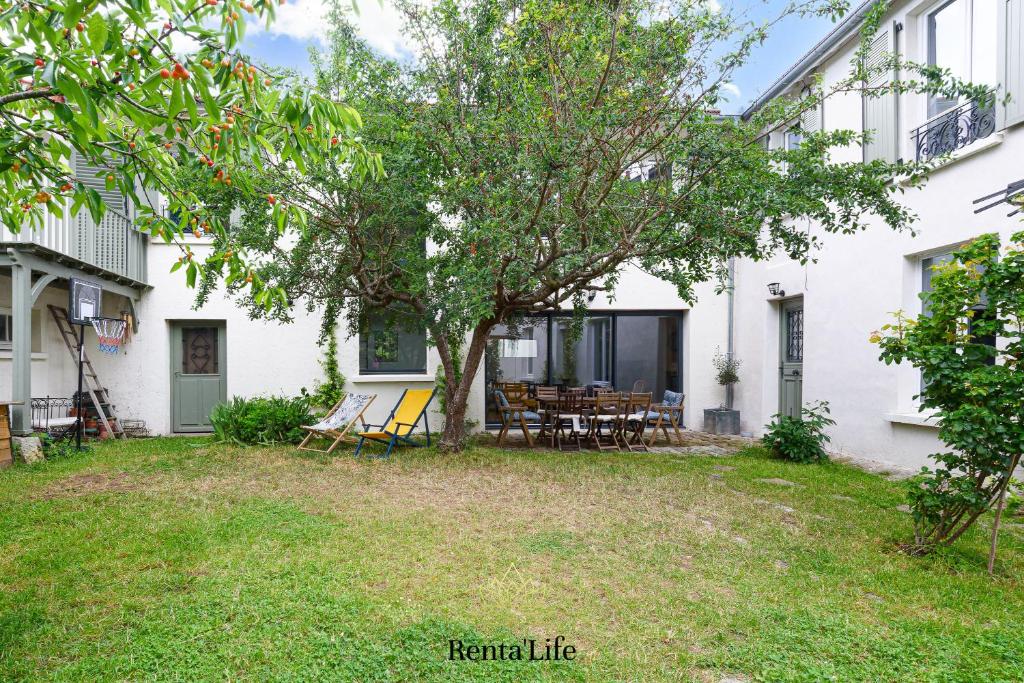 une vue de l'arrière-cour d'une maison blanche dans l'établissement Latignaciens Chariot d'Or - Maison - 7min DisneyLand, à Lagny-sur-Marne