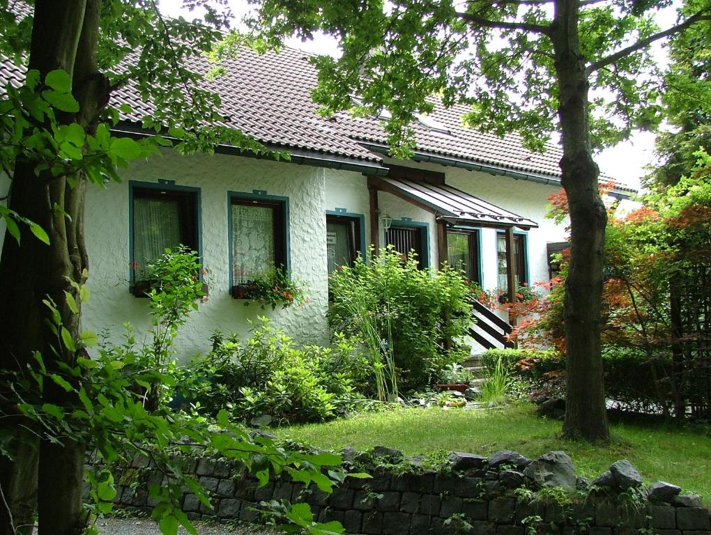 ein weißes Haus mit einem Garten davor in der Unterkunft Ferienwohnung Heger in Bad Steben