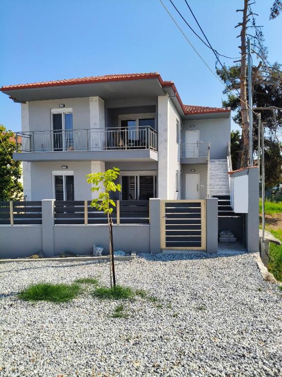 a white house with a small tree in front of it at Irina's Apartment 6 in Psakoudia