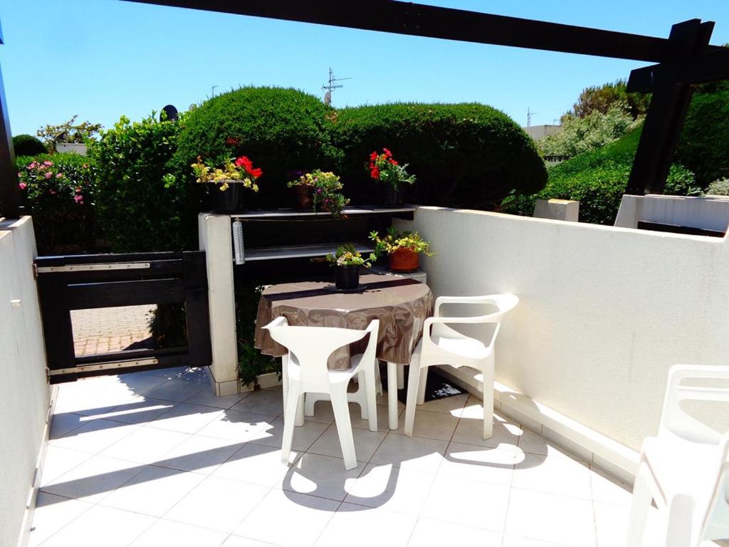un patio avec une table et des chaises sur un balcon dans l'établissement Studio Port Nature PN21- 2 personnes, au Cap d'Agde