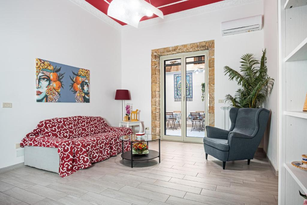 a bedroom with a bed and a chair and a table at GARDEN HOUSE: APARTMENTS AND ROOMS FOR HOLIDAYS in Palermo