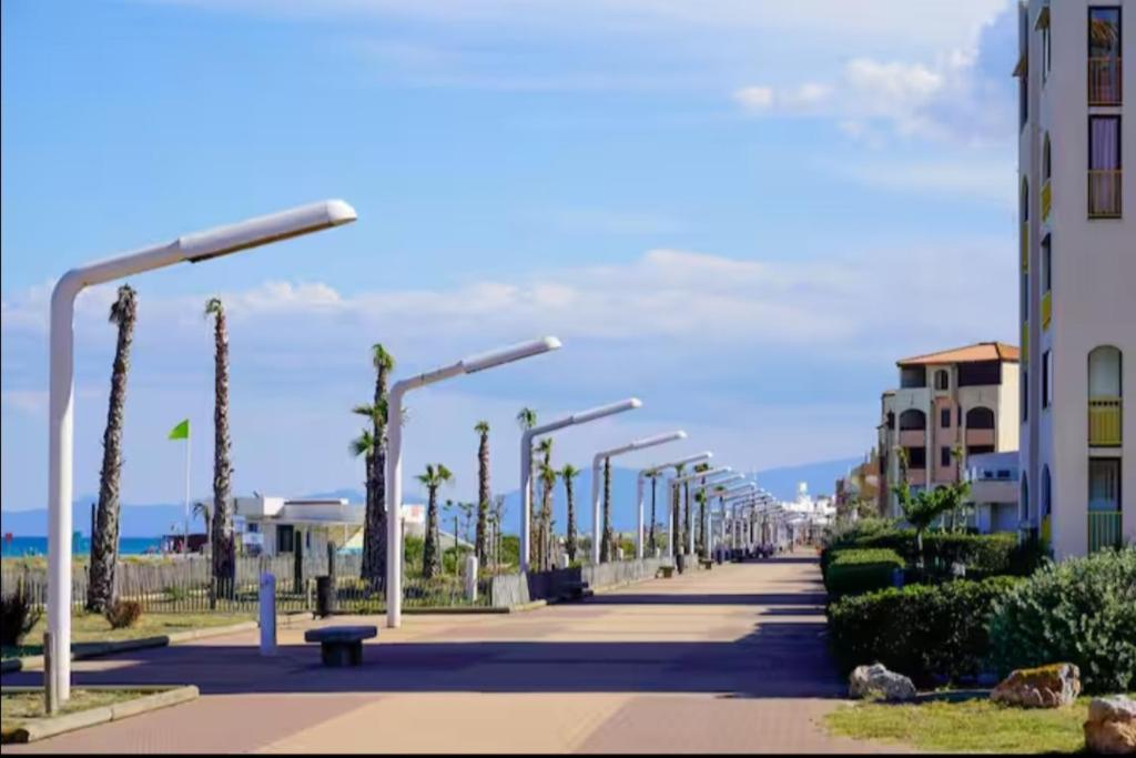 une rangée de feux de rue sur un trottoir à côté d'un bâtiment dans l'établissement Résidence Front de Mer, Appt 5 couchages, au Barcarès