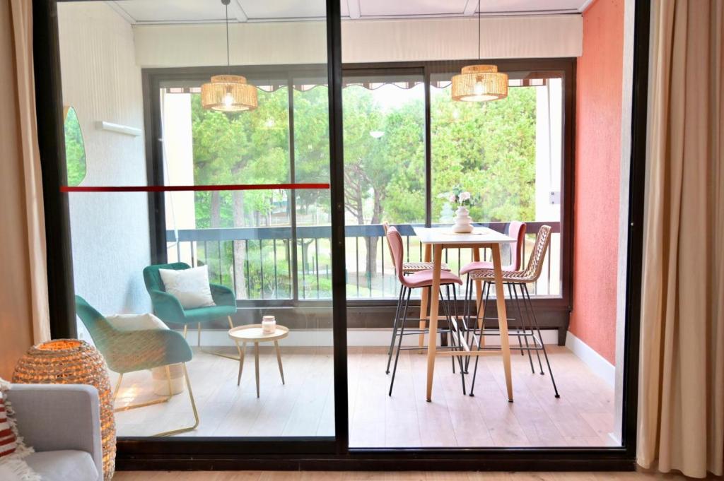 un salon avec une table et des chaises dans une pièce dans l'établissement studio coquet grau du roi, au Grau-du-Roi