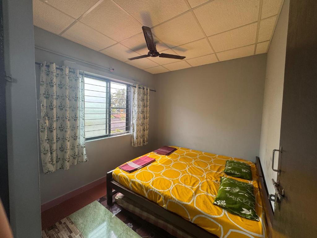 a bedroom with a bed and a window at KENSON'S INN - Non AC - 2 Bedroom Apartment in Mangalore