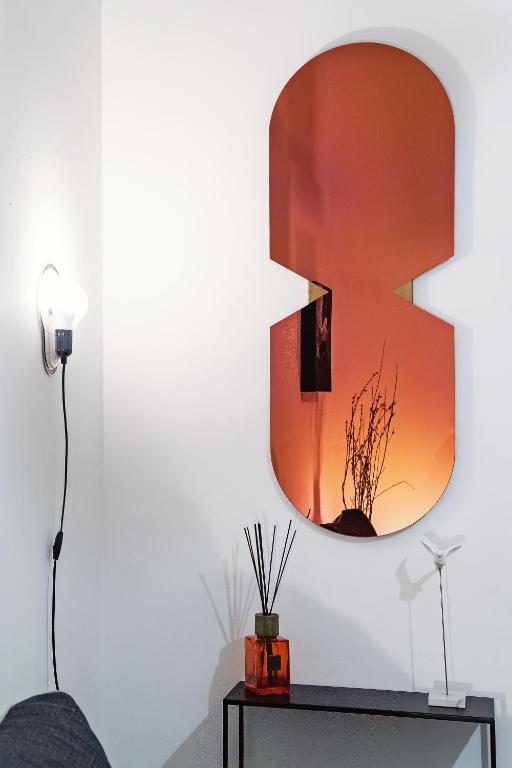 Ein Spiegel hängt an einer Wand neben einem Tisch. in der Unterkunft Loft35 - Vasca Idromassaggio - Nel cuore di Palermo - Self check-in in Palermo
