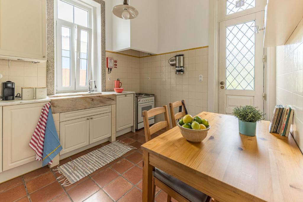 a kitchen with a table with a bowl of fruit on it at Vila Mar Beach House in Arcozelo