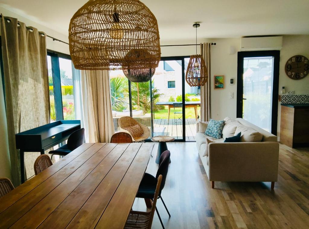 un salon avec une table et un canapé dans l'établissement SOZEN - Maison bois récente, lumineuse avec terrasse et grand Jardin, proche des plages, à Tréogat