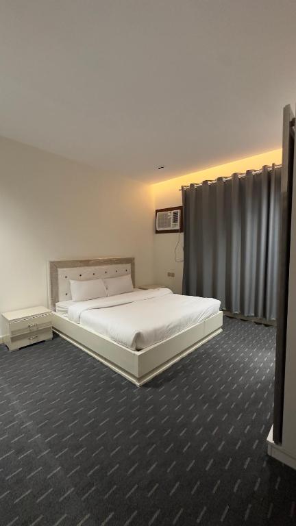 a bedroom with a large white bed in a room at Madain Al Baraka Suites أجنحة مدائن البركة in Medina