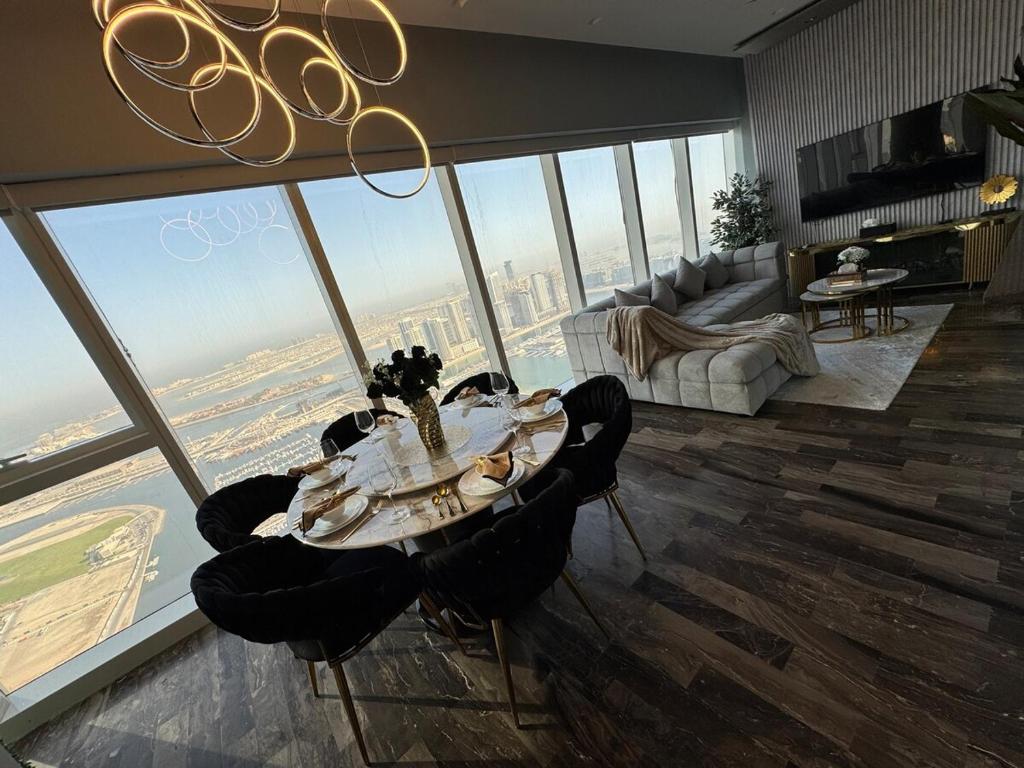 a living room with a table and a large window at Ultra Luxury Palm Dubai Eye Fendi 2BR Damac Height in Sabkhah