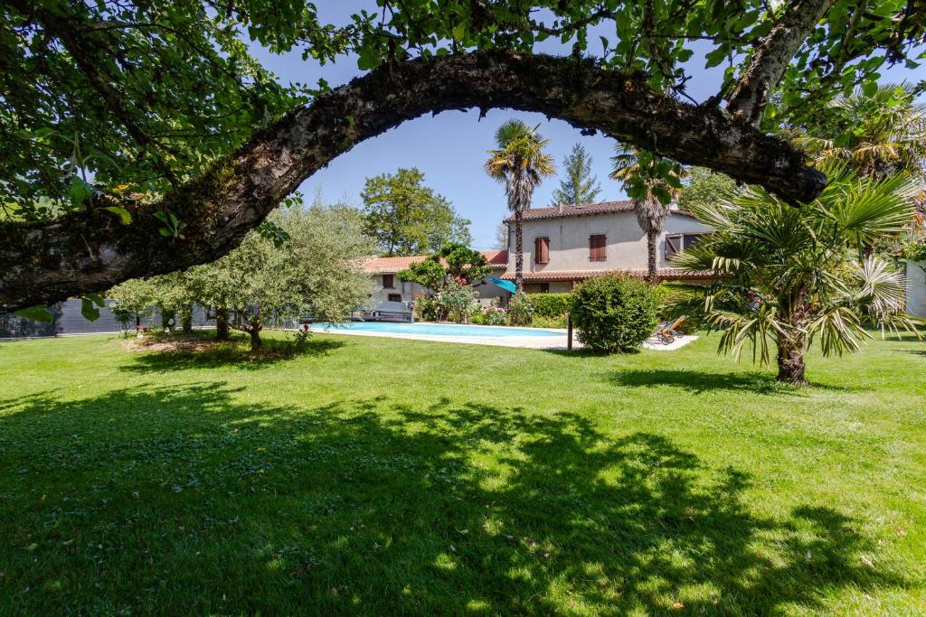une maison avec une cour dotée d'une piscine et d'arbres dans l'établissement Gîte LE RUISSEAU DU BEJEAN, à Sainte-Gemme