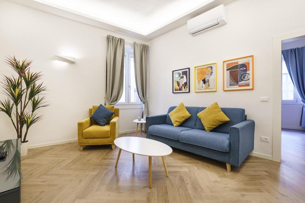 a living room with a blue couch and a table at Designer Apartment in Oltrarno in Florence