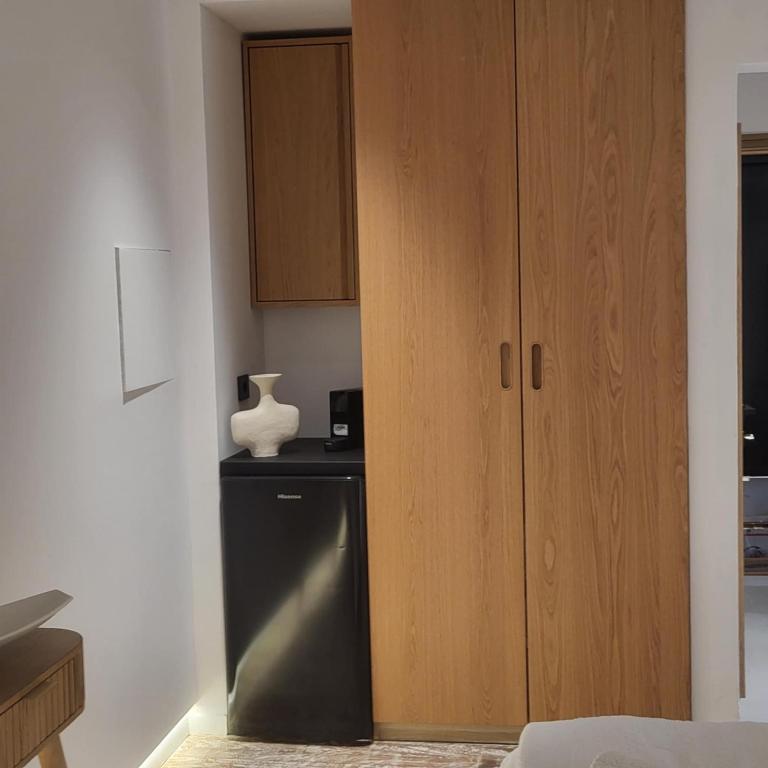 a kitchen with a wooden cabinet and a dishwasher at Oro suites budget in Mikonos