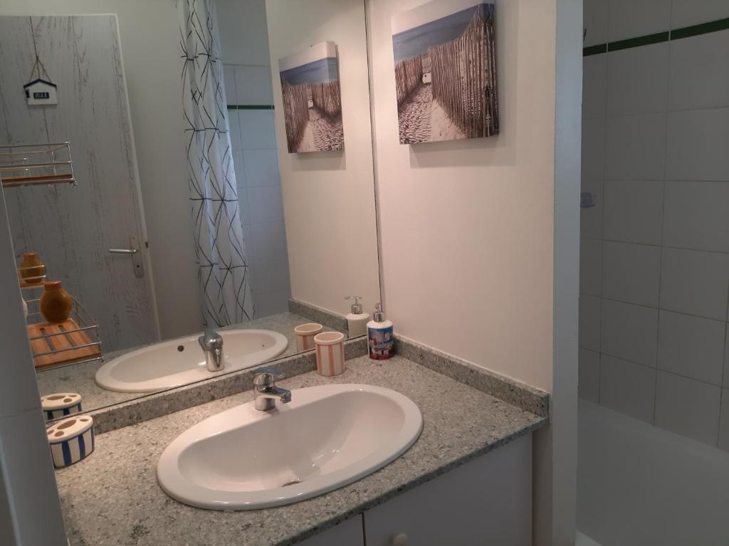 une salle de bain avec deux lavabos et un grand miroir dans l'établissement Vacation home in a wooded park, à Saint-Jean-de-Monts
