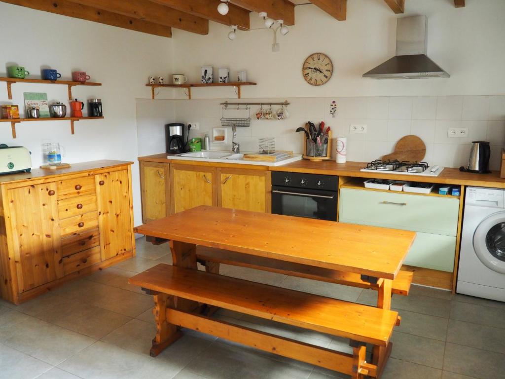 - une cuisine avec une table en bois et une cuisinière dans l'établissement Gîte Le petit Bonheur dans la vallée du Tarn, à Ambialet