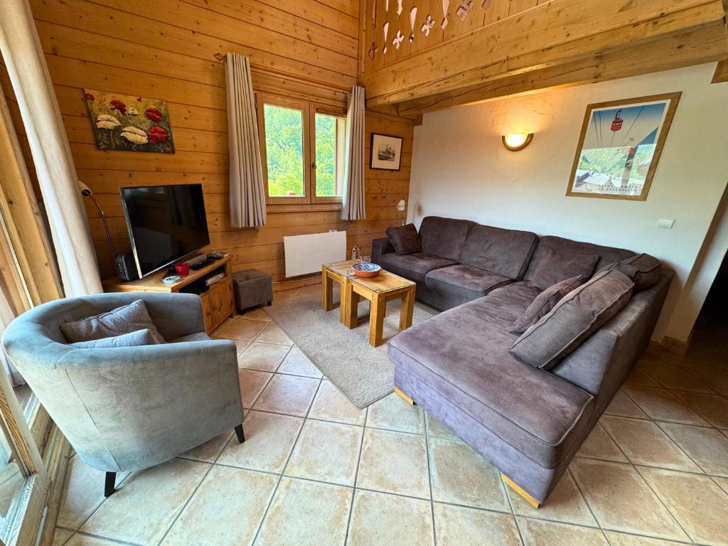un salon avec un canapé et une télévision dans l'établissement Appartement Confort+ avec Balcon et Parking - 3 Chambres, 6 pers, WiFi - Les Menuires - FR-1-452-315, à Praranger
