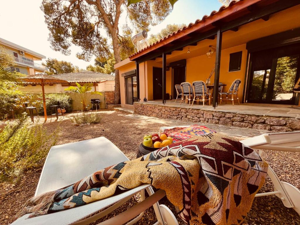 a patio with a table and chairs in front of a house at Garden villa two-bedroom suite in Vari