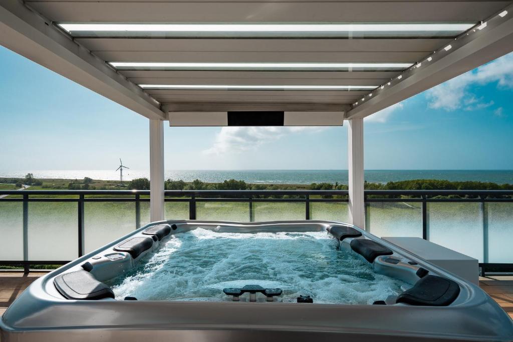 a hot tub on a balcony with a view of the ocean at Panoramasuite The Turm - Penthouse in Wustrow