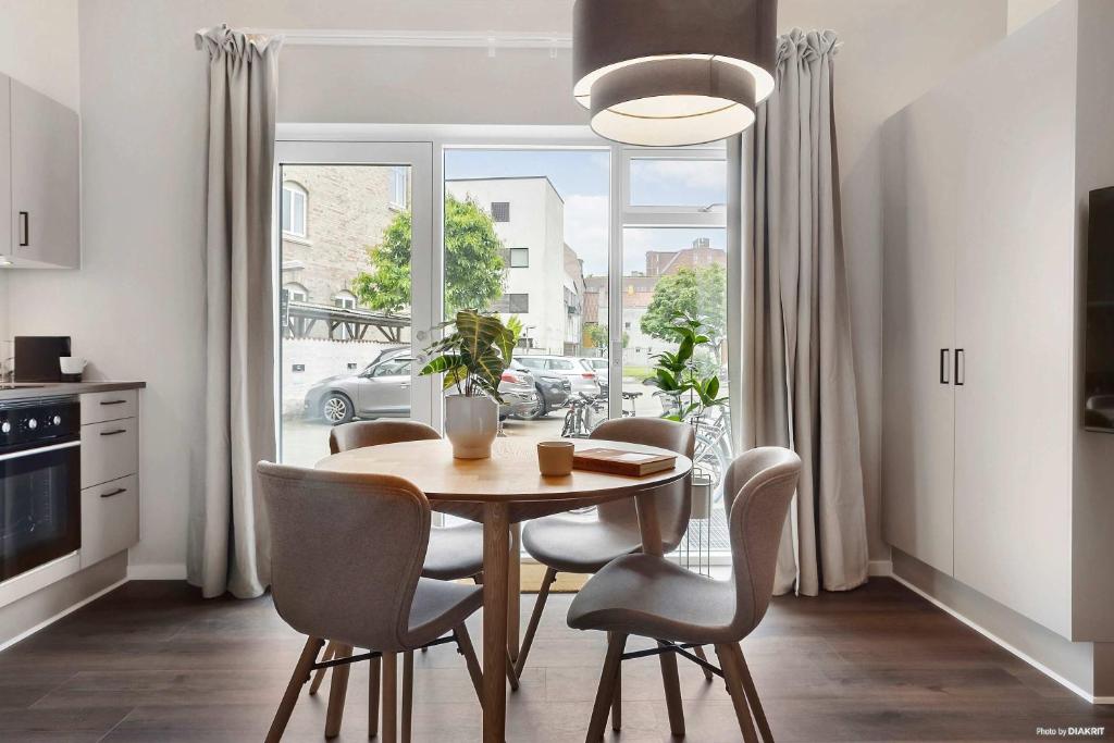 a kitchen with a table and chairs and a window at Cozy Scandinavian Studio with Direct Entry in Aarhus