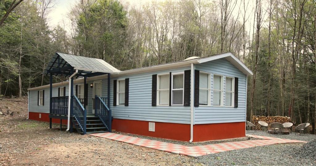 une petite maison au milieu des bois dans l'établissement Riverfront Cottage with Sauna & Hot Tub, à Liberty