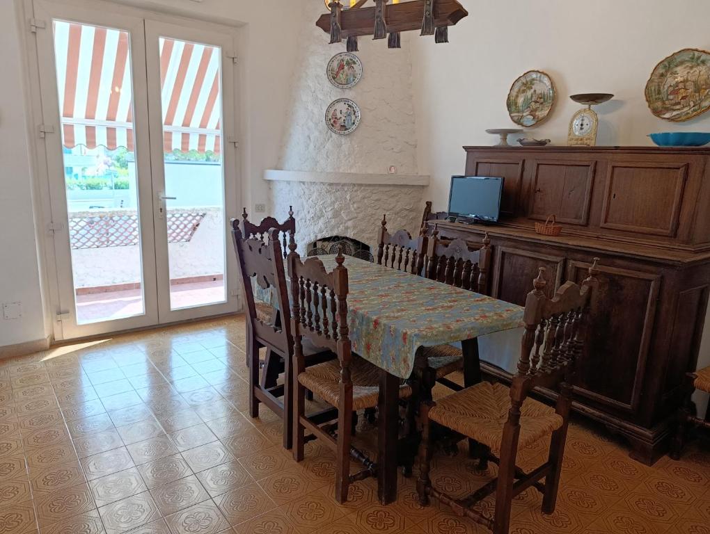 a dining room with a table and chairs and a television at Casa da Oscar in Marcelli