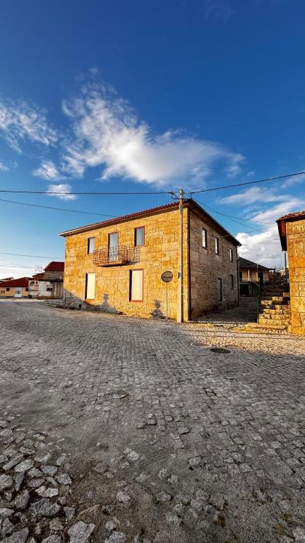 an old brick building sitting on the side of a street at Casa das Antas in Antas