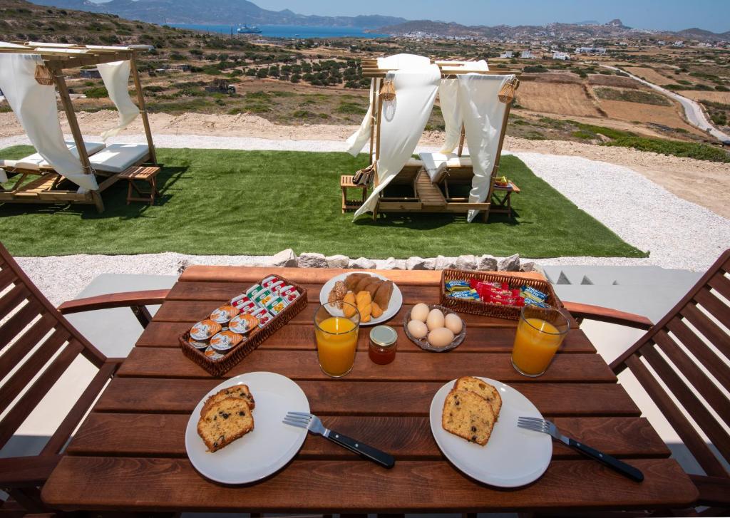 a wooden table with plates of food on it at Esperos Panoramic View Suites in Mytakas