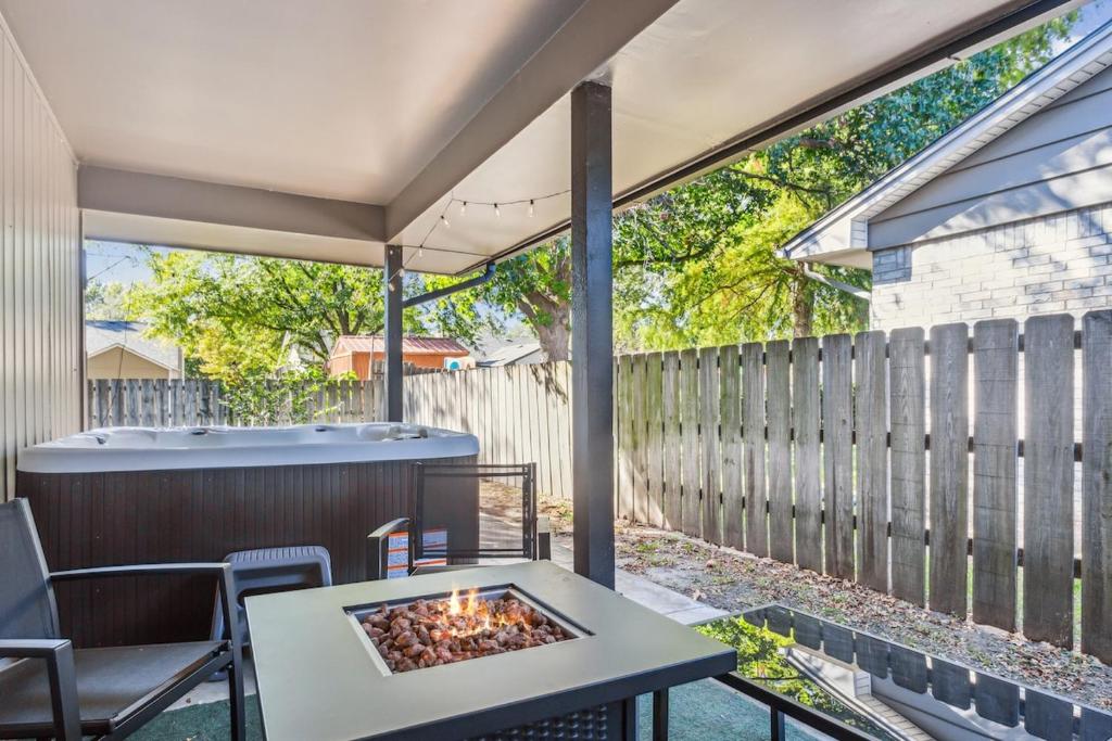 a patio with a fire pit and a fence at HotTub, Cinema & Games in a Quiet Neighborhood in Wichita