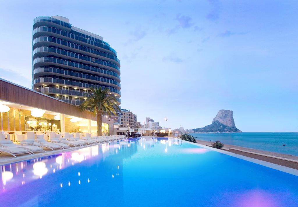 una gran piscina junto a un edificio y al océano en SOLYMAR Gran Hotel en Calpe